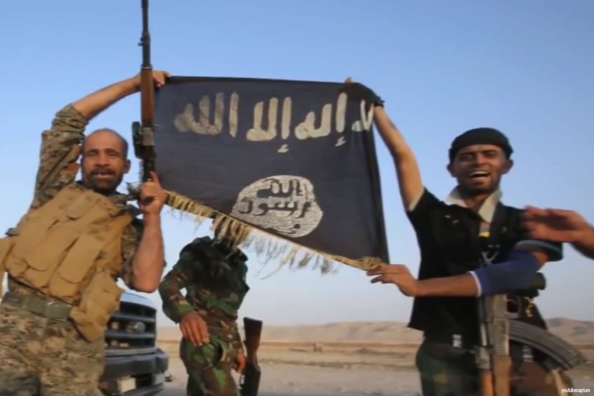 Militantes del Daesh izan su bandera.