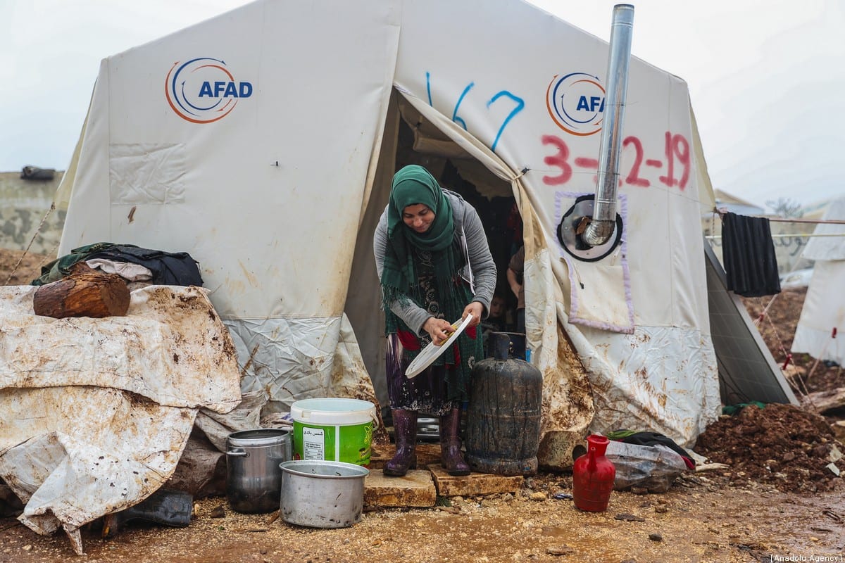Se ve a una mujer siria frente a su tienda de campaña en un campamento donde se alojan familias sirias, que se han visto obligadas a desplazarse debido a los ataques llevados a cabo por el régimen de Assad y Rusia, en Idlib, Siria, el 10 de enero de 2020 [Agencia Esra Hacioğlu / Anadolu]