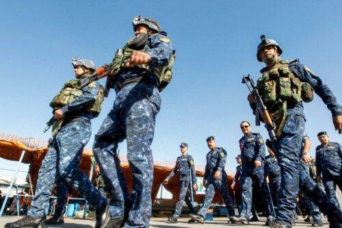 Iraqi policemen are seen walking while securing Shiite Muslim pilgrims marching on the outskirts of the Iraqi capital Baghdad towards the central Iraqi shrine city of Karbala on October 27, 2018, ahead of the Arbaeen religious festival which marks the 40th day after Ashura, commemorating the seventh century killing of the Prophet Mohammed's grandson Imam Hussein. (Photo by SABAH ARAR / AFP) (Photo credit should read SABAH ARAR/AFP/Getty Images)
