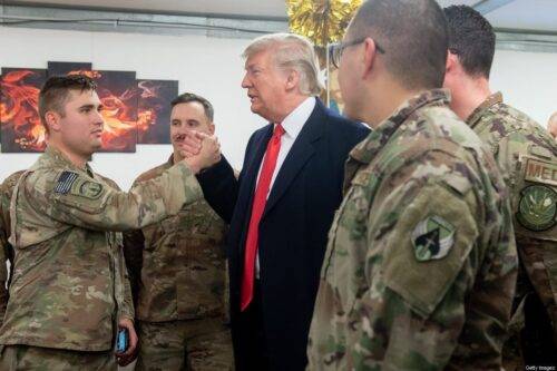 El presidente de los Estados Unidos, Donald Trump, saluda a los miembros del ejército de los Estados Unidos durante un viaje no anunciado a la base aérea de Al Asad en Irak el 26 de diciembre de 2018. (Foto de SAUL LOEB / AFP) (El crédito de la foto debe leer SAUL LOEB / AFP a través de Getty Images)