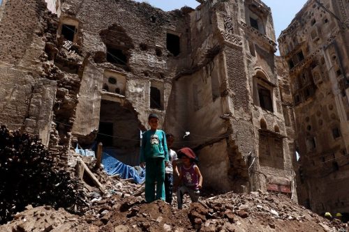 Niños de pie sobre los escombros de un edificio histórico después de que se derrumbara parcialmente debido a las fuertes lluvias en la Ciudad Vieja de Sanaa, el 13 de agosto de 2020 en Sana'a, Yemen [Mohammed Hamoud/Getty Images]