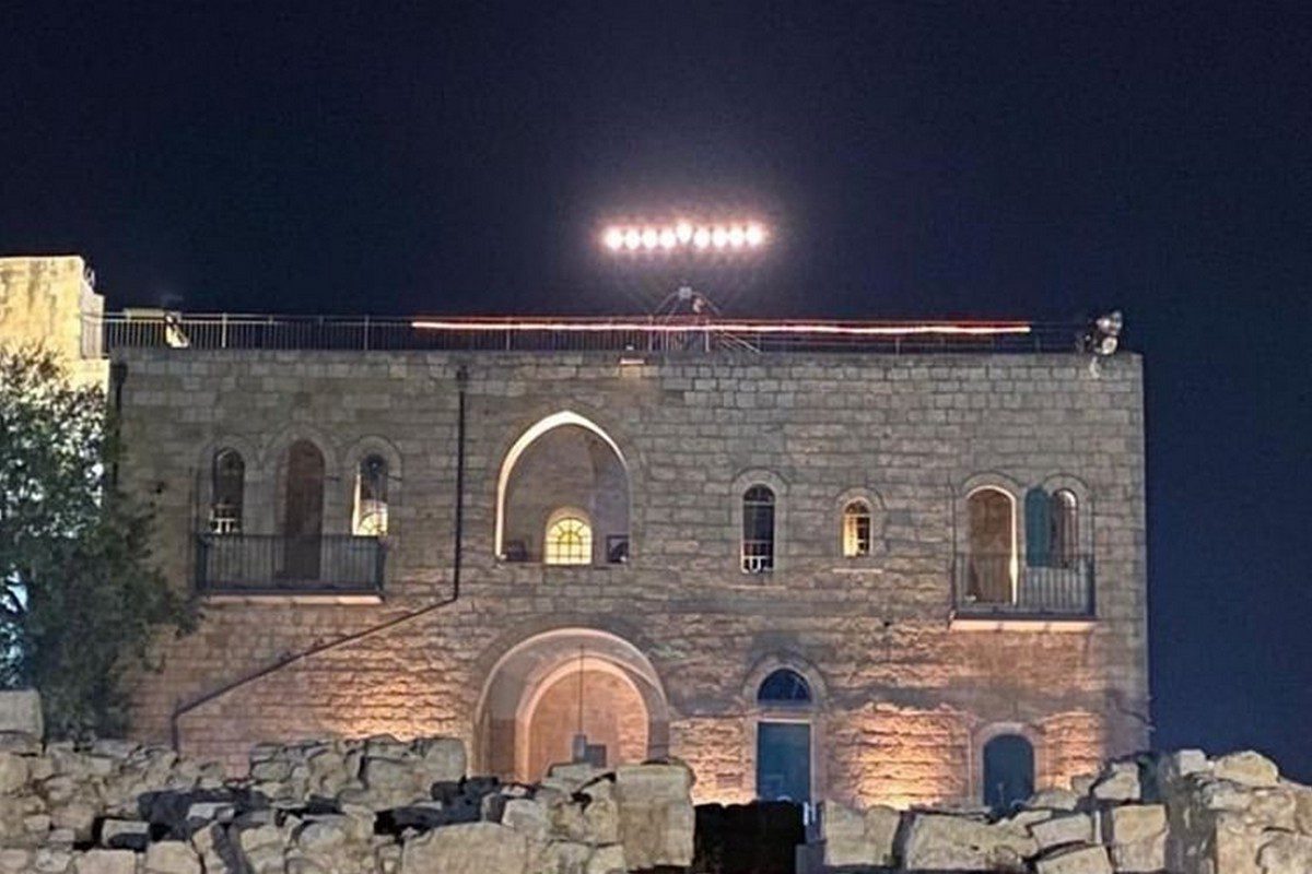 Colonos colocan la menorá en el tejado de una mezquita de jerusalén